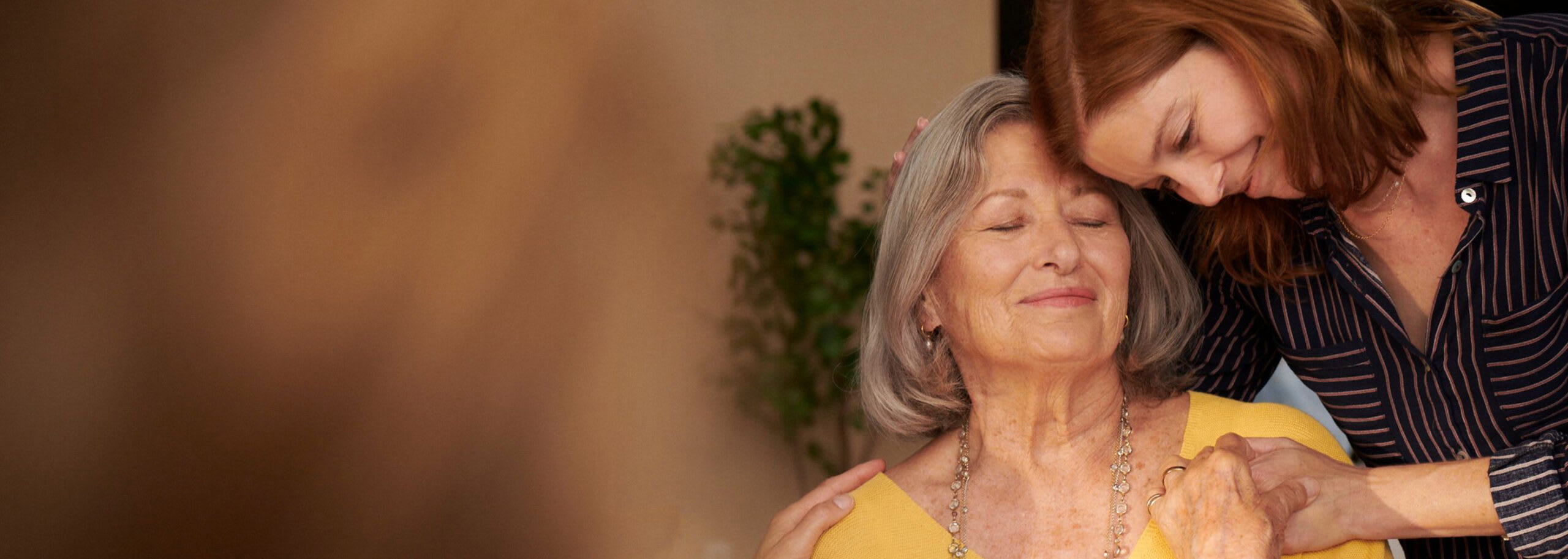Senior with daughter sharing an embrace